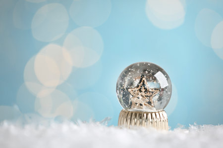 Beautiful snow globe with stars against blurred Christmas lights. Space for text