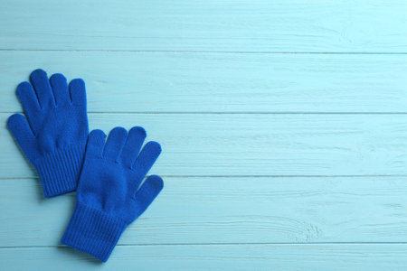 Pair of stylish woolen gloves on light blue wooden background, flat lay. Space for textの写真素材