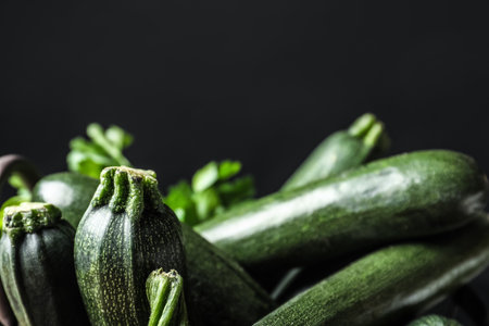 Raw green zucchinis on black background, closeupの写真素材
