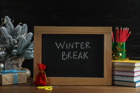 Chalkboard with phrase Winter Break, Christmas decor and stationery on wooden table. Holiday conceptの写真素材