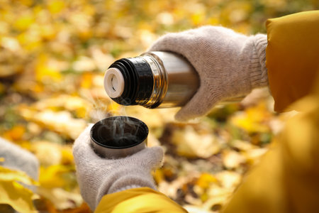 Woman pouring drink from flask into cap outdoors, closeupの写真素材