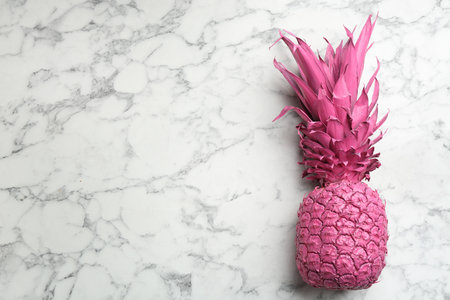 Pink pineapple on white marble background, top view with space for text. creative conceptの写真素材