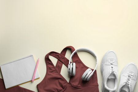 Flat lay composition with sportswear and notebook on light background, space for text. Gym workout planの写真素材