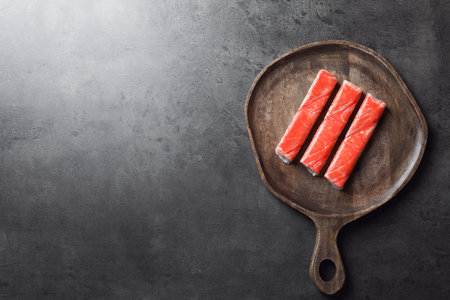 Crab sticks on gray table, top view. Space for textの写真素材