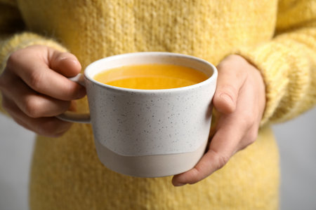 Woman holding cup with sea buckthorn tea, closeup viewの写真素材