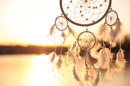 Beautiful handmade dream catcher near the river at sunset. Space for textの写真素材