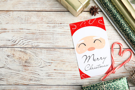 Flat lay composition with Christmas card and gift boxes on white wooden background, space for textの写真素材