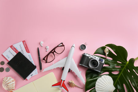 Flat lay composition with toy airplane and travel items on pink background. Space for textの写真素材
