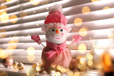 Cute decorative snowman on window sill, bokeh effectの写真素材