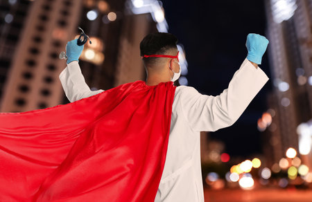 Doctor dressed as superhero on night city background. Medical workers fighting dangerous diseasesの写真素材