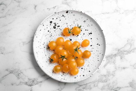 Ripe yellow tomatoes on white marble table, top viewの写真素材