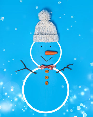 Snowman with hat and bow tie on light blue background, flat lay. bokeh effectの写真素材