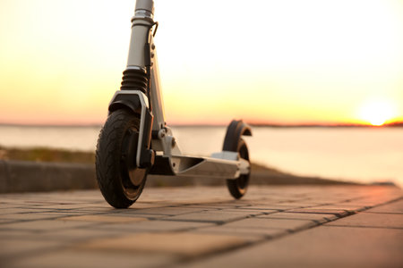 Modern electric kick scooter outdoors at sunset, closeupの写真素材