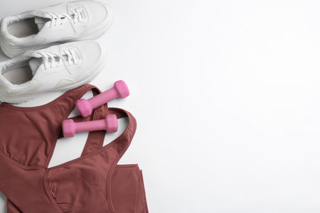 Sportswear and dumbbells on white background, flat lay with space for text. Gym workoutの写真素材