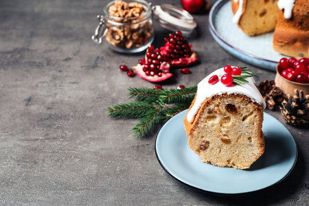 Composition with piece of traditional homemade Christmas cake on gray table, closeup. Space for text