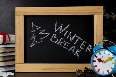 Blackboard with text Winter Break and Christmas decor on table. School holidaysの写真素材