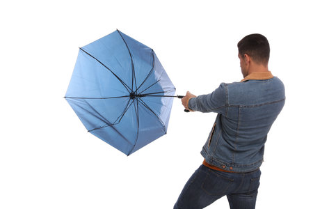 Man with umbrella caught in thick of wind on white backgroundの写真素材
