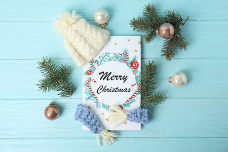 Flat lay composition with Christmas card and festive decor on light blue wooden backgroundの写真素材