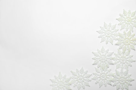 Beautiful decorative snowflakes on white background, flat lay. Space for textの写真素材