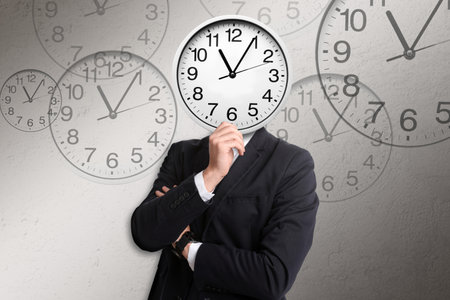 Time management concept. Businessman with clock instead of head on light gray backgroundの写真素材