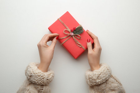 Woman holding Christmas gift box on white background, top viewの写真素材