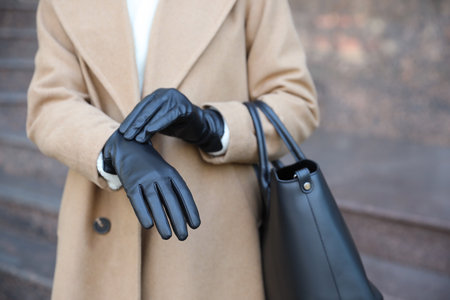 Woman with leather gloves and stylish bag on city street, closeupの写真素材