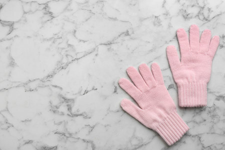 Stylish pink gloves on white marble background, flat lay. Space for textの写真素材