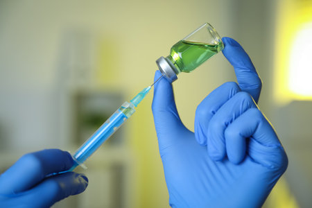 Doctor filling syringe with medication in clinic, closeup. Vaccination and immunizationの写真素材