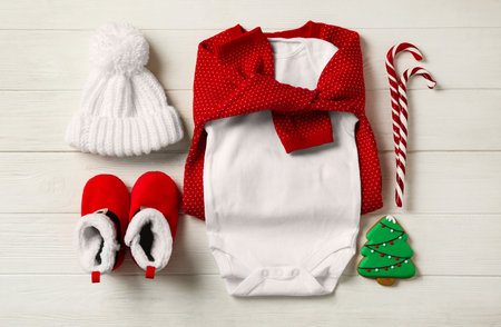 Flat lay composition with cute Christmas baby clothes on white wooden backgroundの写真素材
