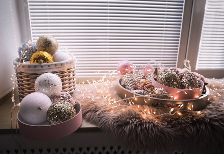 Beautiful Christmas tree baubles and fairy lights on window sill indoorsの写真素材
