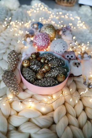 Beautiful Christmas tree baubles, toys and fairy lights on white knitted fabric