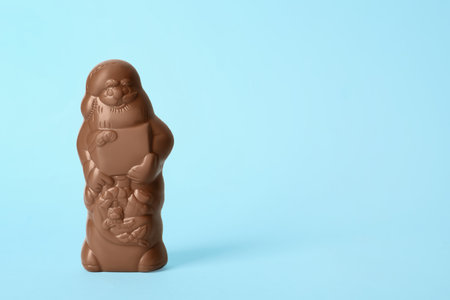 Unwrapped chocolate Santa Claus on light blue background. Space for textの写真素材