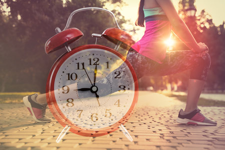 Workout time. Double exposure of woman doing exercise on sunny morning outdoors and alarm clock