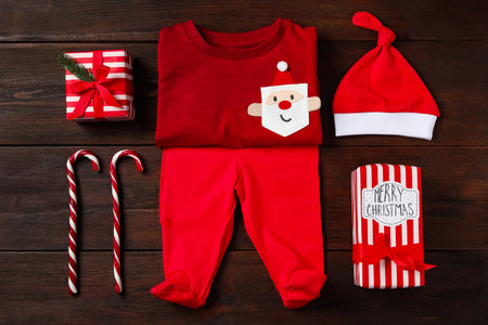 Flat lay composition with cute Christmas baby clothes on wooden backgroundの写真素材