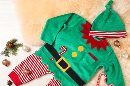 Flat lay composition with cute Christmas baby clothes on white wooden backgroundの写真素材