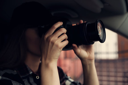 Private detective with camera spying from car, focus on lensの写真素材