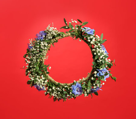 Beautiful handmade flower wreath on red backgroundの写真素材