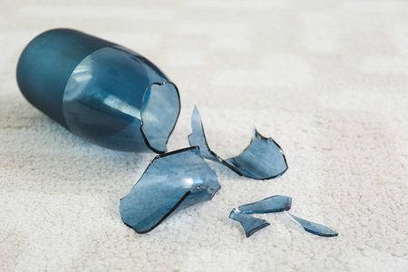 Broken blue glass vase on carpet, closeupの写真素材