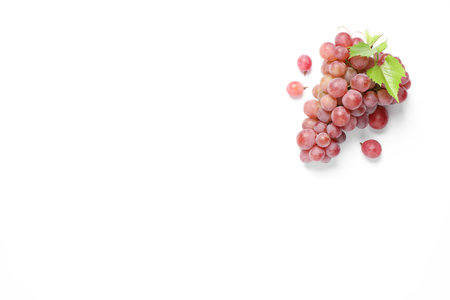 Bunch of ripe red grapes with green leaves on white background, top viewの写真素材