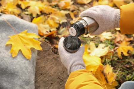Woman pouring drink from flask into cap outdoors, closeupの写真素材