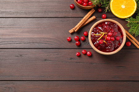 Flat lay composition with cranberry sauce on wooden table, space for textの写真素材