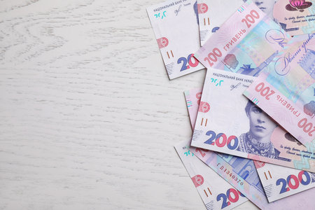 Ukrainian money on white wooden background, flat lay. Space for textの写真素材