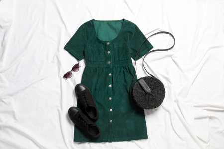 Flat lay composition with stylish green dress on white fabricの写真素材
