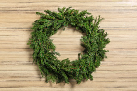 Christmas wreath made of fir branches on wooden backgroundの写真素材