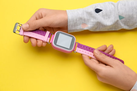 Girl with stylish smart watch on yellow background, closeupの写真素材