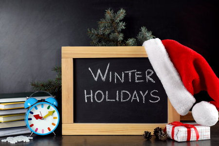 Blackboard with text Winter Holidays and Christmas decor on tableの写真素材
