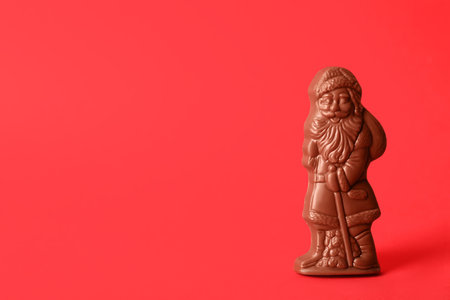 Sweet chocolate Santa Claus candy on red background, space for textの写真素材