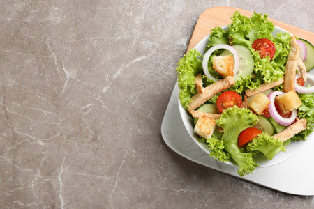 Delicious fresh chicken salad on grey table, top view. Space for textの写真素材