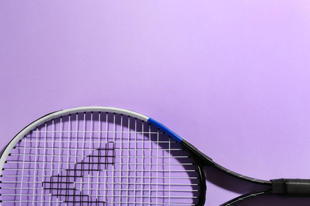 Tennis racket on violet background, top view. Space for textの写真素材