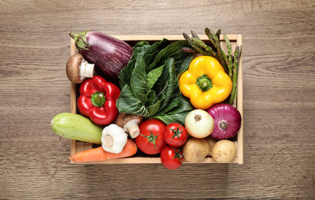 Fresh vegetables in crate on wooden table, top viewの写真素材